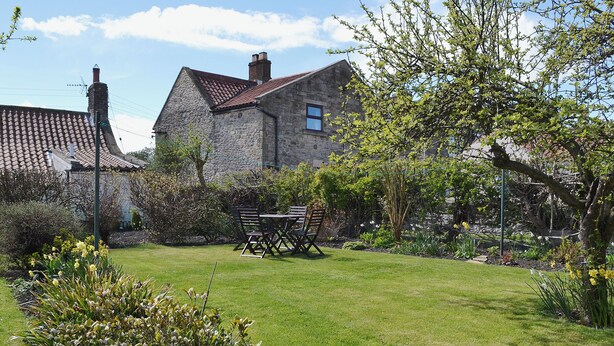A stone house with a tiled roof, a grassy garden, and a table with chairs. - 1 bedroom accommodation in Caldwell, near Richmond (Caldwell, near Richmond)