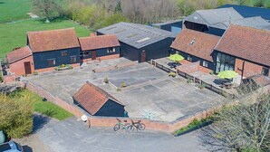 Luchtbeeld van een landgoed met verschillende gebouwen, een ruime binnenplaats en omliggende velden.