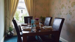 A dining table set with plates, glasses, and a vase of flowers. - 2 bedroom accommodation in Southport (Southport)
