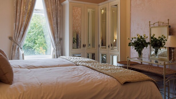 A bedroom with a large bed, a wardrobe, and a mirror. - 2 bedroom accommodation in Southport (Southport)