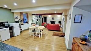 Un espacio habitable compacto con cocina, comedor y un sofá rojo.