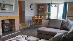A cozy living room with a fireplace, a sofa, and a patterned rug. - 2 bedroom accommodation in St Neot, near Liskeard (St Neot, near Liskeard)