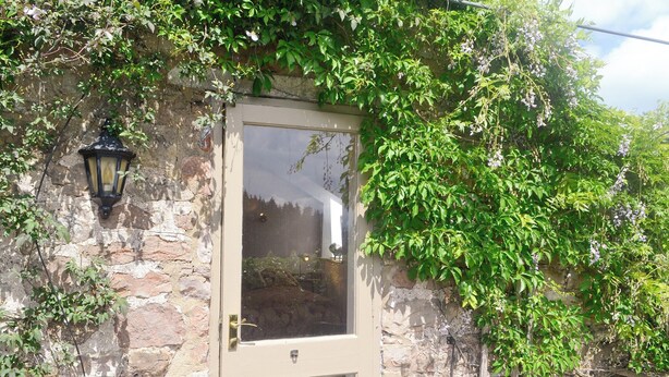 Un mur de pierre avec une porte en bois et une lanterne.