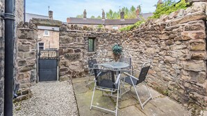 A stone wall with a metal table and chairs in a courtyard. - 2 bedroom accommodation in Darley Bridge, near Matlock (Darley Bridge, near Matlock)