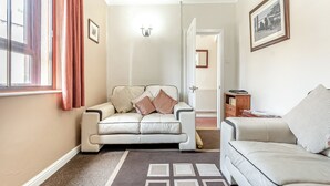 A living room with a beige sofa, a patterned rug, and a framed picture on the wall. - 2 bedroom accommodation in Darley Bridge, near Matlock (Darley Bridge, near Matlock)