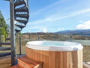 A hot tub on a wooden deck with a scenic mountain view. - Jill Strawbale House- UKC2935 (Strontian, near Fort William)