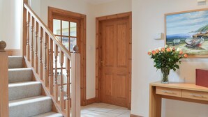 Una escalera con barandillas de madera que conduce a una puerta con un ventanal.
