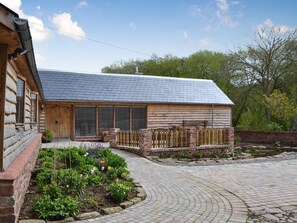 A wooden cabin with a sloped roof, large windows, and a wooden porch.
