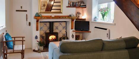 A cozy living room with a fireplace, a television, and a comfortable sofa.