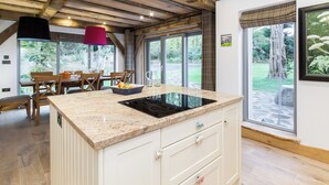 A kitchen with a granite countertop, white cabinetry, and a large window. - 4 bedroom accommodation in Largs (Largs)