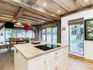 A kitchen with a granite countertop, white cabinetry, and a large window. - 4 bedroom accommodation in Largs (Largs)