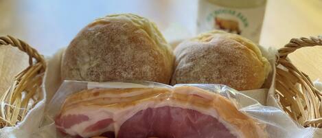 A basket containing bread, a ham, and eggs.