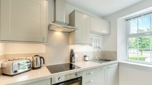 A modern kitchen with a built-in oven, a stovetop, and a sink. - 2 bedroom accommodation in Meathop, near Grange-over-Sands (Meathop, near Grange-over-Sands)