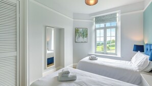 A hotel room with two beds, a large window with a view, a hanging light fixture, and a painting on the wall. - 2 bedroom accommodation in Meathop, near Grange-over-Sands (Meathop, near Grange-over-Sands)