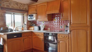 Une cuisine avec des meubles en bois, un four à micro-ondes, un grille-pain et une cuisinière.