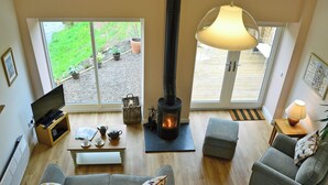 Un salon chaleureux avec une cheminée, un canapé, une table basse et un téléviseur.