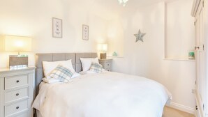 Een slaapkamer met een bed, nachtkastjes, een kroonluchter, wanddecoratie en een ster decoratie.