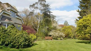 A house with a sloped roof and a well-maintained lawn. - 1 bedroom accommodation in Dalwood, near Axminster (Dalwood, near Axminster)