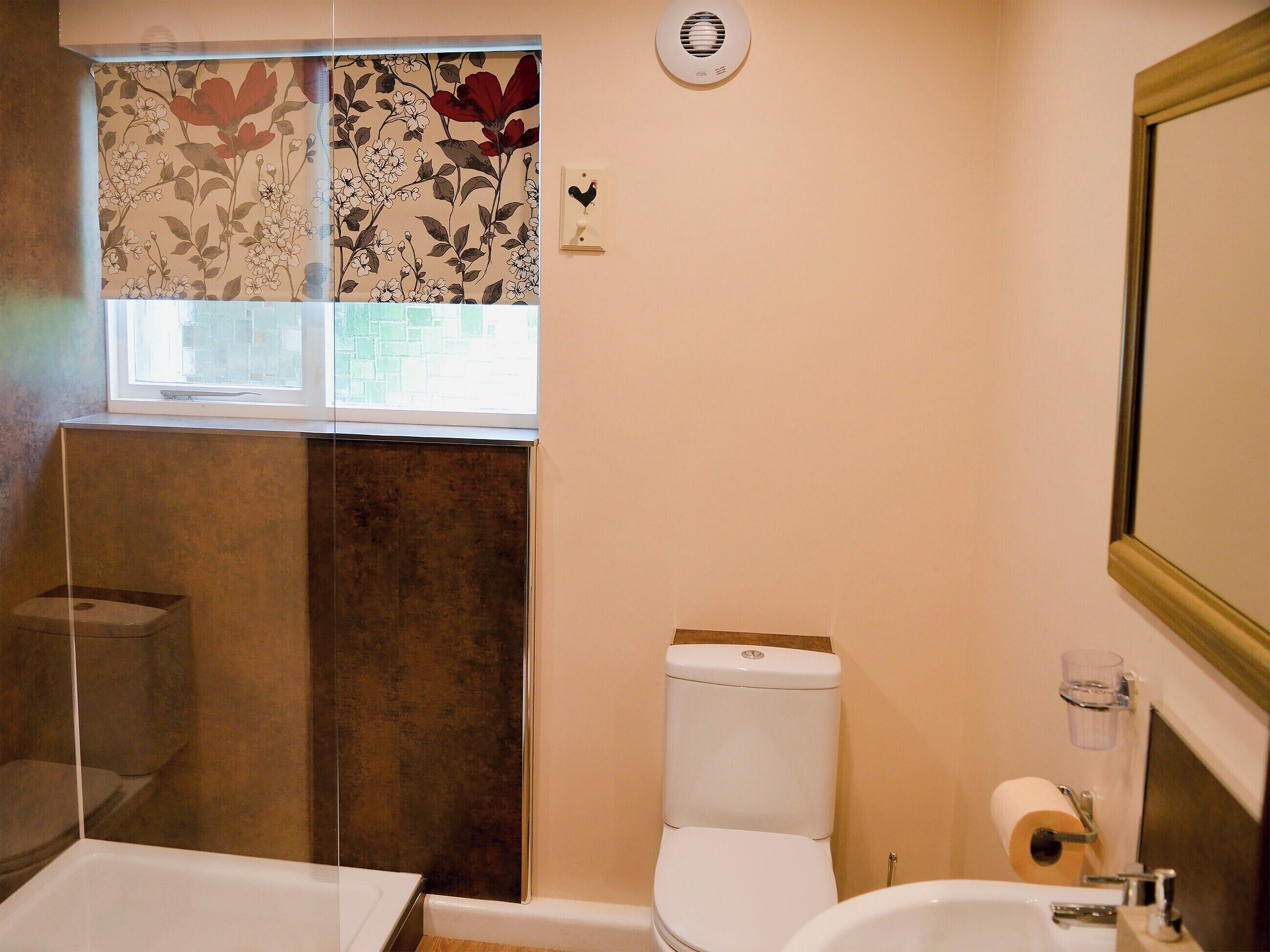 Une salle de bain avec des toilettes, une douche et un lavabo.