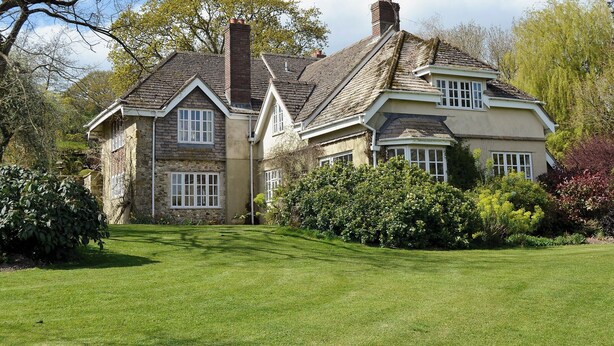 A traditional stone house with a steeply pitched roof, a chimney, and a well-maintained lawn. - 1 bedroom accommodation in Dalwood, near Axminster (Dalwood, near Axminster)
