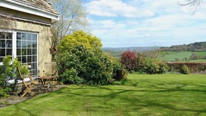 A house with a large window, a garden with a lawn, and a view of the countryside. - 1 bedroom accommodation in Dalwood, near Axminster (Dalwood, near Axminster)