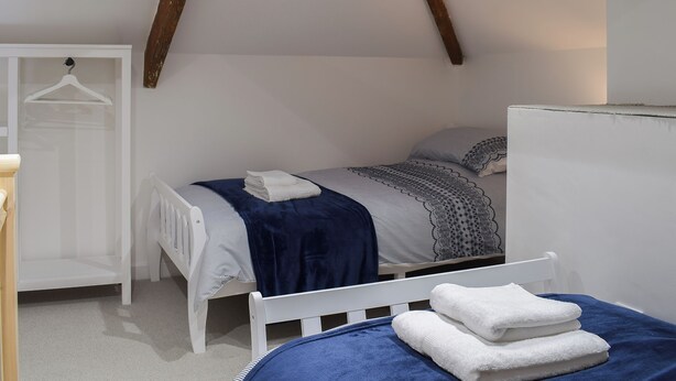 Een slaapkamer met een bed, een kledingkast en een hanglamp.