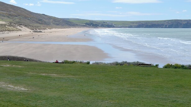 A coastal landscape with a sandy beach, grassy areas, and cliffs. - 2 bedroom accommodation in Woolacombe (Woolacombe)