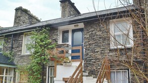 A stone house with a wooden staircase leading to a blue door. - 2 bedroom accommodation in Bowness-on-Windermere (Bowness-on-Windermere)
