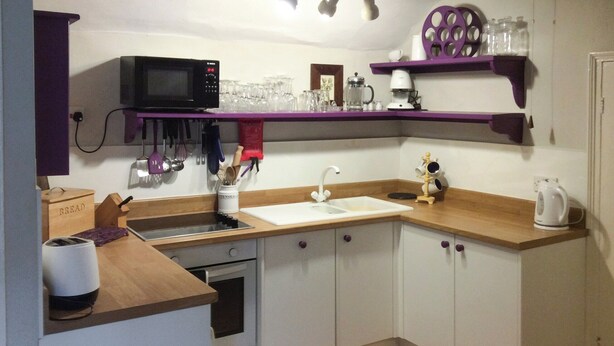 A kitchen with a microwave, sink, and wooden countertop. - The Plover - UKC2845 (Blakeney, near Holt)