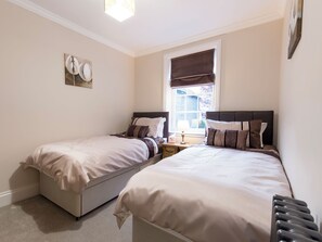A bedroom with two beds, a window with a view, and a bedside table with a lamp. - Beverley Minster House (Beverley)