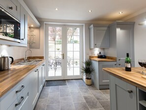 A modern kitchen with a wooden countertop, a Bosch dishwasher, and a potted plant.