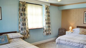 A bedroom with two beds, a nightstand with a lamp, and a chair. - 1 bedroom accommodation in Bunbury (Bunbury)