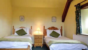 A double room with two wooden beds, each with a pillow and a bedside table. - 2 bedroom accommodation in Trelawnyd, near Prestatyn (Trelawnyd, near Prestatyn)