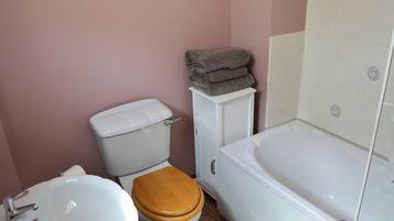 A bathroom with a toilet, sink, and bathtub.