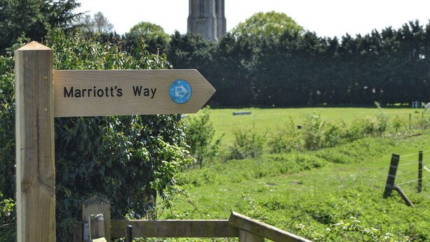 Een houten bord met 'Marriott's Way' en pijlen die de richting aangeven.