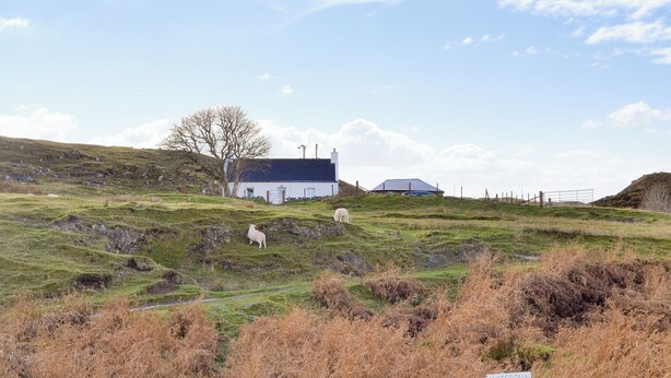 A rural landscape with a sign indicating a waterfall cottage.