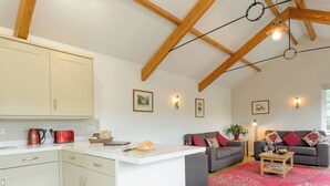 A kitchen with white cabinets, a red kettle, and a wooden ceiling with exposed beams. - 2 bedroom accommodation in Loddiswell Station, near Kingsbridge (Loddiswell Station, near Kingsbridge)