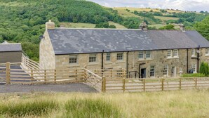 A stone building with a slate roof, a wooden gate, and a grassy foreground. - 4 bedroom accommodation in Beck Hole, near Whitby (Beck Hole, near Whitby)