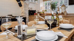 A dining table set with white plates, glasses, and a loaf of bread. - 3 bedroom accommodation in Barley, near Barrowford (Barley, near Barrowford)