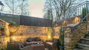 A stone-walled outdoor seating area with wicker furniture and lanterns. - 3 bedroom accommodation in Barley, near Barrowford (Barley, near Barrowford)