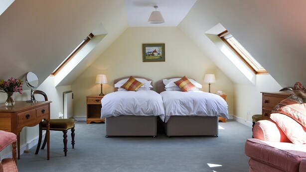 A bedroom with two beds, a desk, a chair, and a dresser. - Broad Cottage Boathouse (Ranworth, near Wroxham)
