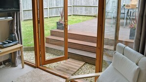 A modern living room with a sliding glass door leading to a patio. - 2 bedroom accommodation in Swan Pool, near Falmouth (Swan Pool, near Falmouth)