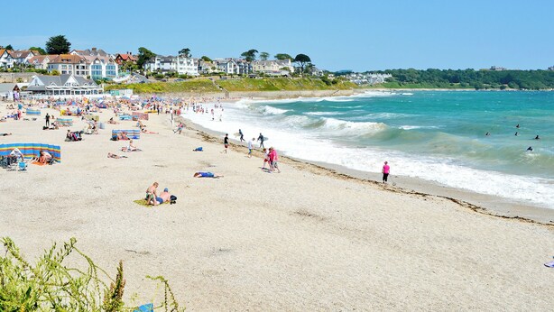 A beach with people sunbathing and swimming, houses in the background, and a clear sky. - 2 bedroom accommodation in Swan Pool, near Falmouth (Swan Pool, near Falmouth)