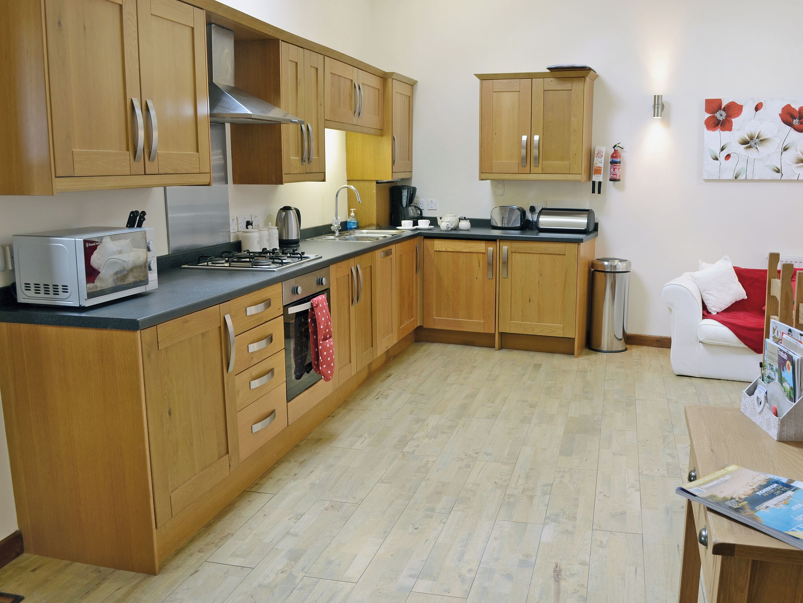 A kitchen with wooden cabinets, a microwave, a stove, and a sink.