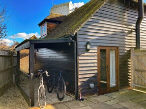 Une maison en bois avec un porche abrité, un vélo et une porte.