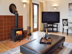 Una sala de estar acogedora con chimenea, televisor de pantalla plana y un área de descanso confortable.