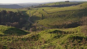 A rural landscape with rolling hills, a winding road, and scattered buildings. - 3 bedroom accommodation in Bakewell (Bakewell)