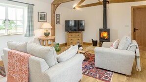 A living room with a fireplace, two sofas, a TV, and a window with curtains. - The Old Dairy-UKC2112 (Royal Wootton Bassett)