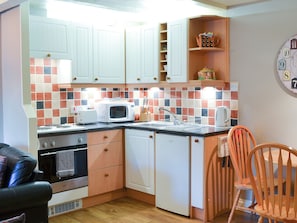 A compact kitchen with white cabinets, a microwave, a toaster, and a sink.