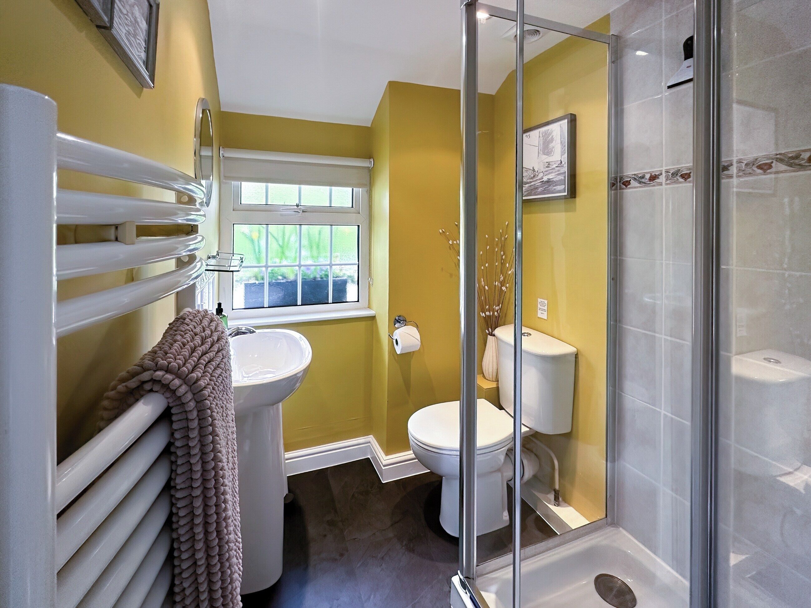 A bathroom with a toilet, sink, and shower.